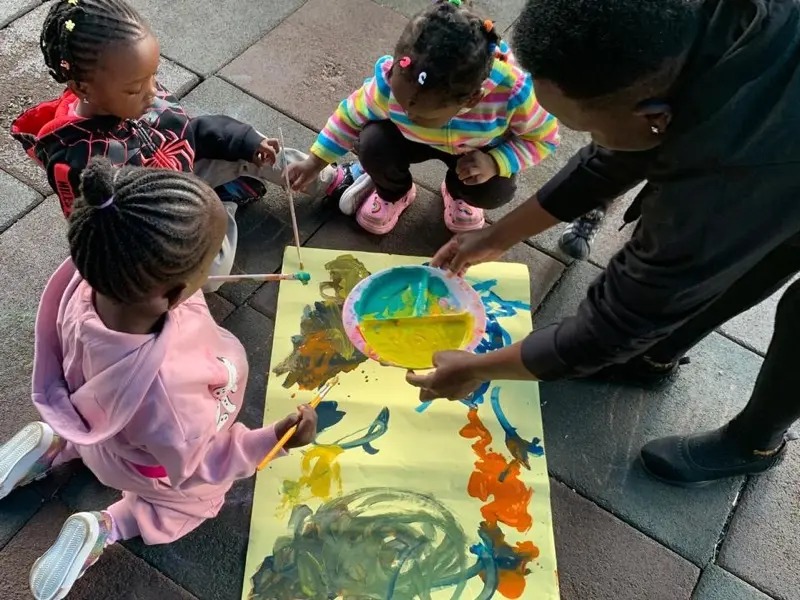 Children painting at easels in the garden