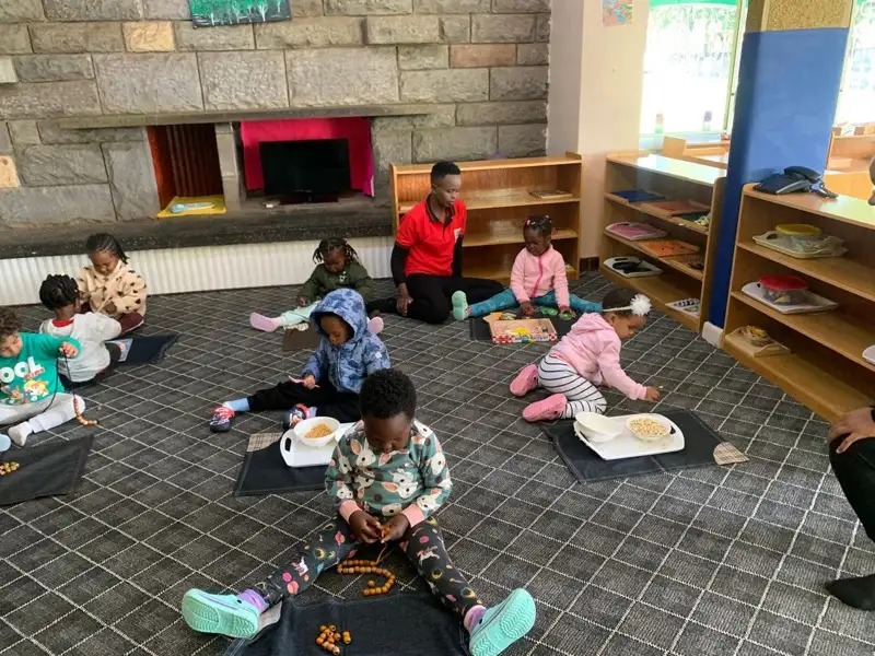 Children exploring Montessori materials on the floor