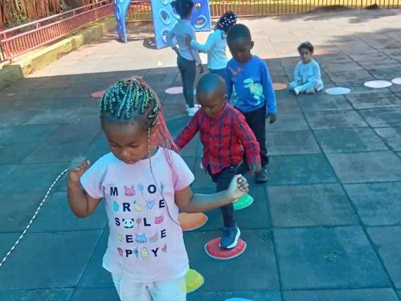 Children stepping on coloured stones at the playground