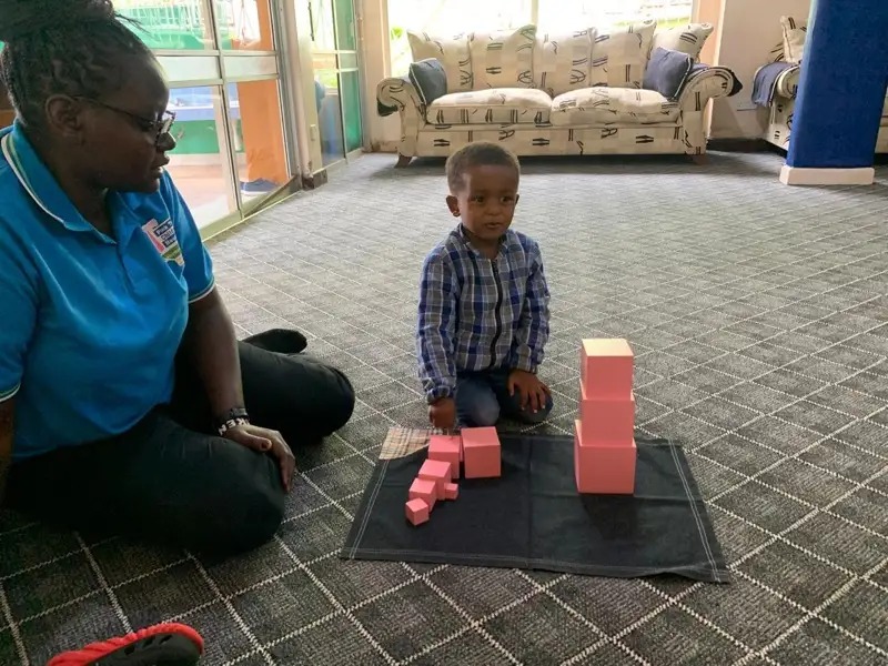 Boy building the pink tower material