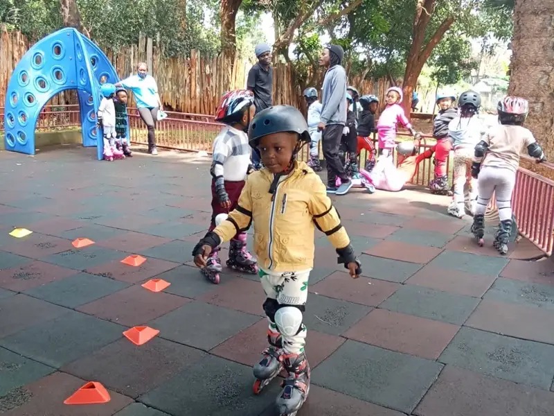 Child roller skating in a yellow jacket